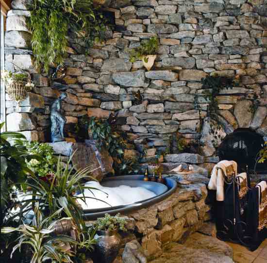 Mary and James recoated a plain white tub with a truck-bed liner so it would look more like stone and have a safe, non-slip surface. Water trickles over a flat stone into the romantic tub-for-two.